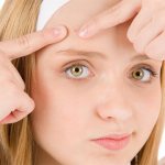 девушка держит пальцами лоб